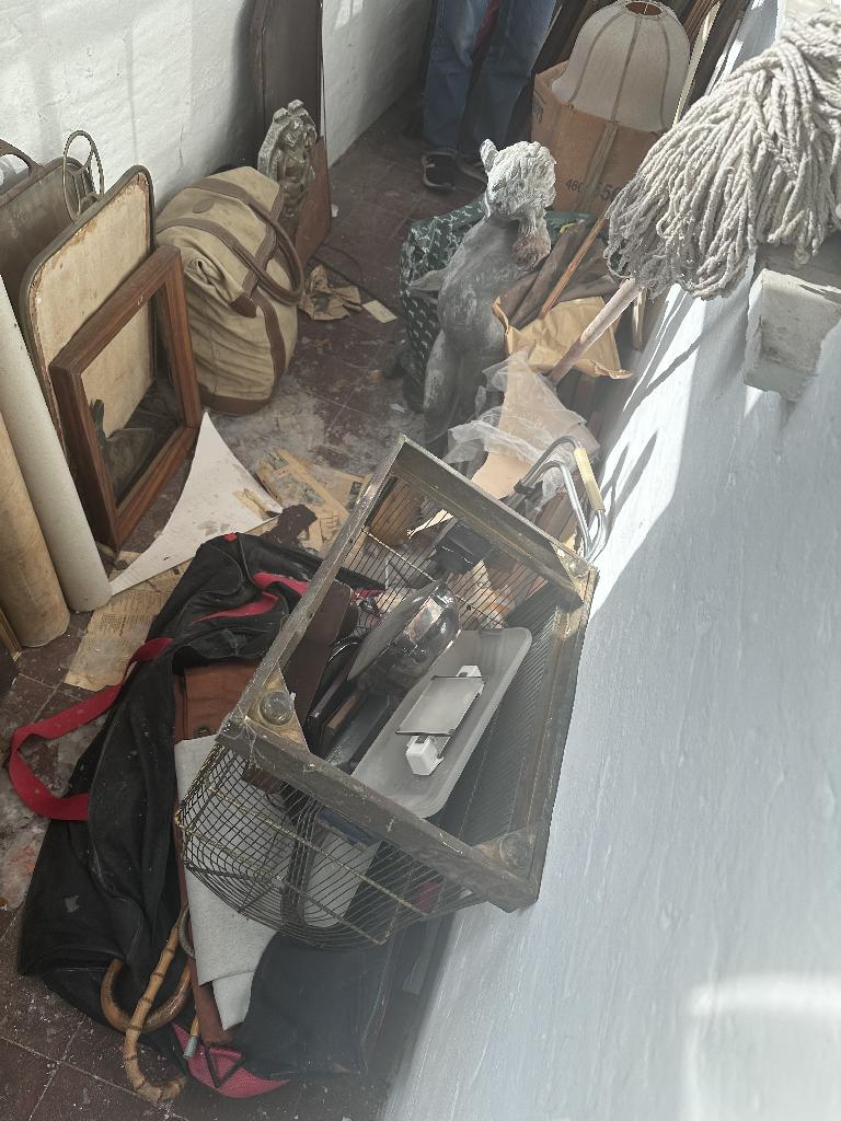 Household clutter clearance in Chelsea before service, showing a cluttered floor corner