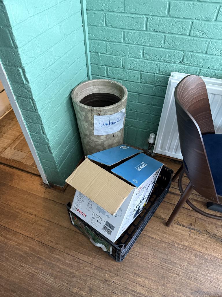 Household utility area clearance in Richmond before clearance showing boxes and waste stacked in a room corner