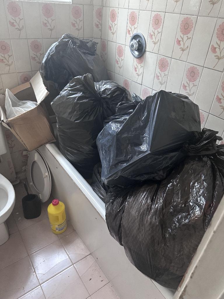 Flat clearance in Chelsea before service, showing black bin bags in the bathroom