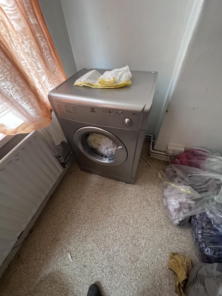 Flat clearance in Rotherhithe before the job, showing a washing machine area with bags and stored waste