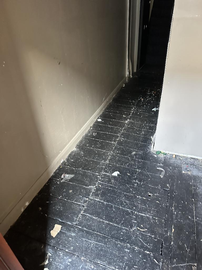 Internal household clearance in Clapham after service, showing an open corridor with waste removed