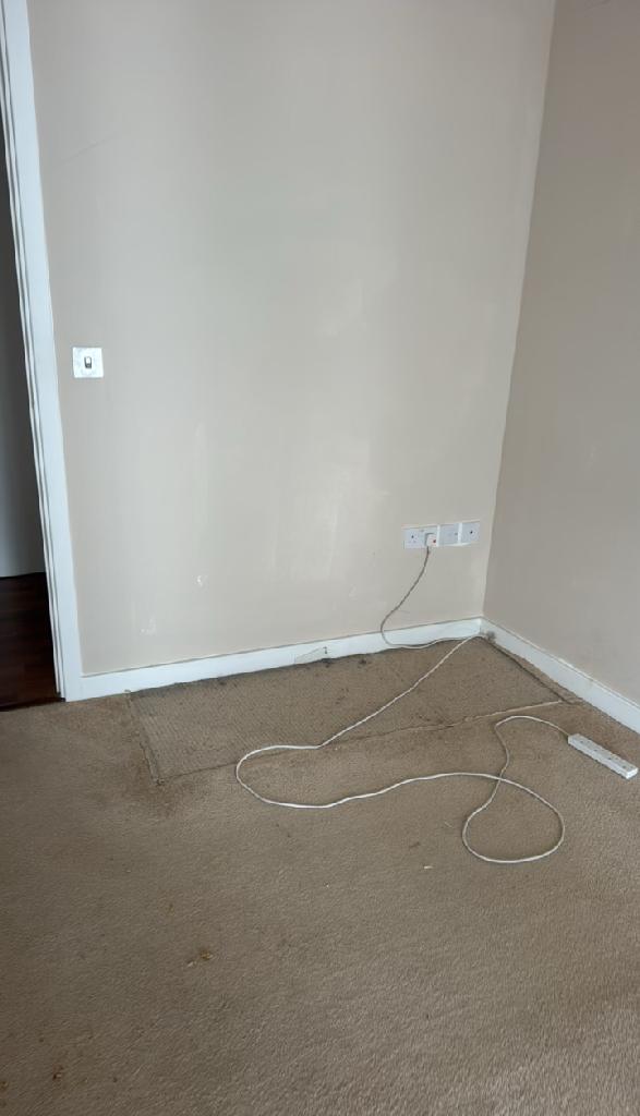Furniture and bulky item removal in Dalston after clearance, showing the room corner clean with open carpeted floor space