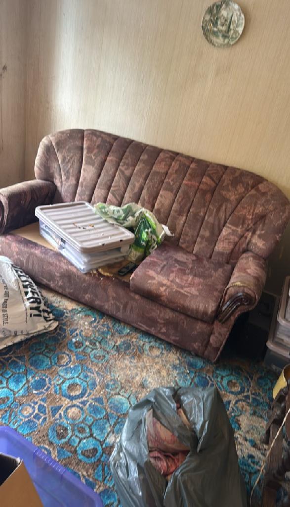 Sofa area with clutter and bags in Wembley Park before rubbish removal
