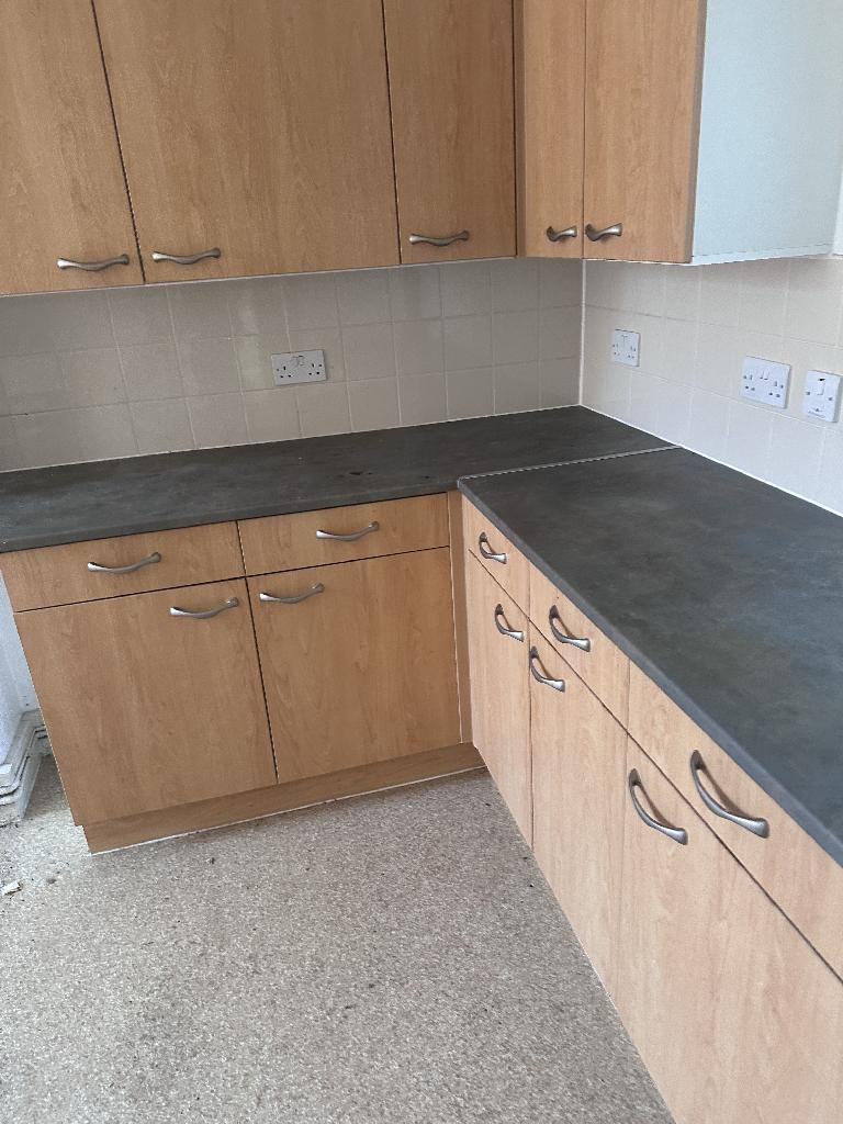 Flat clearance in Rotherhithe after completion, showing a clean kitchen worktop and cleared cabinet fronts