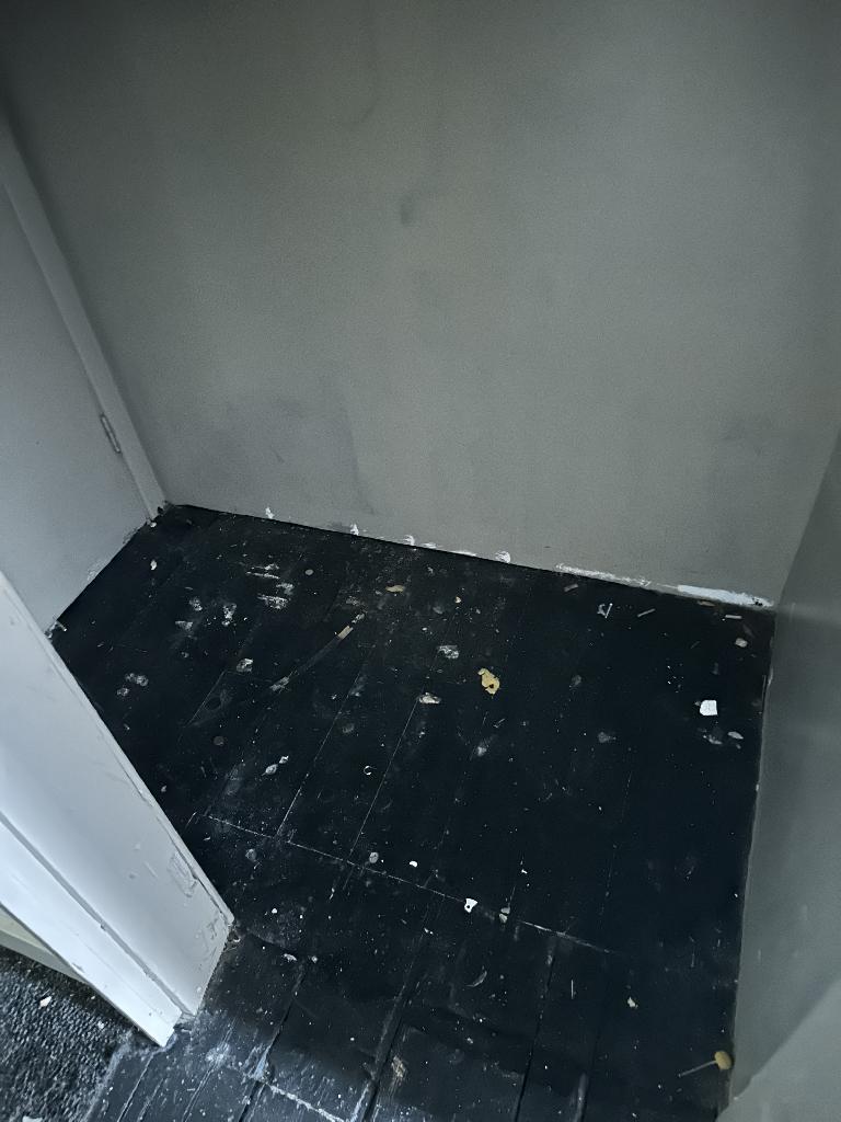 Internal household clearance in Clapham after service, showing a cleared corner area with debris reduced