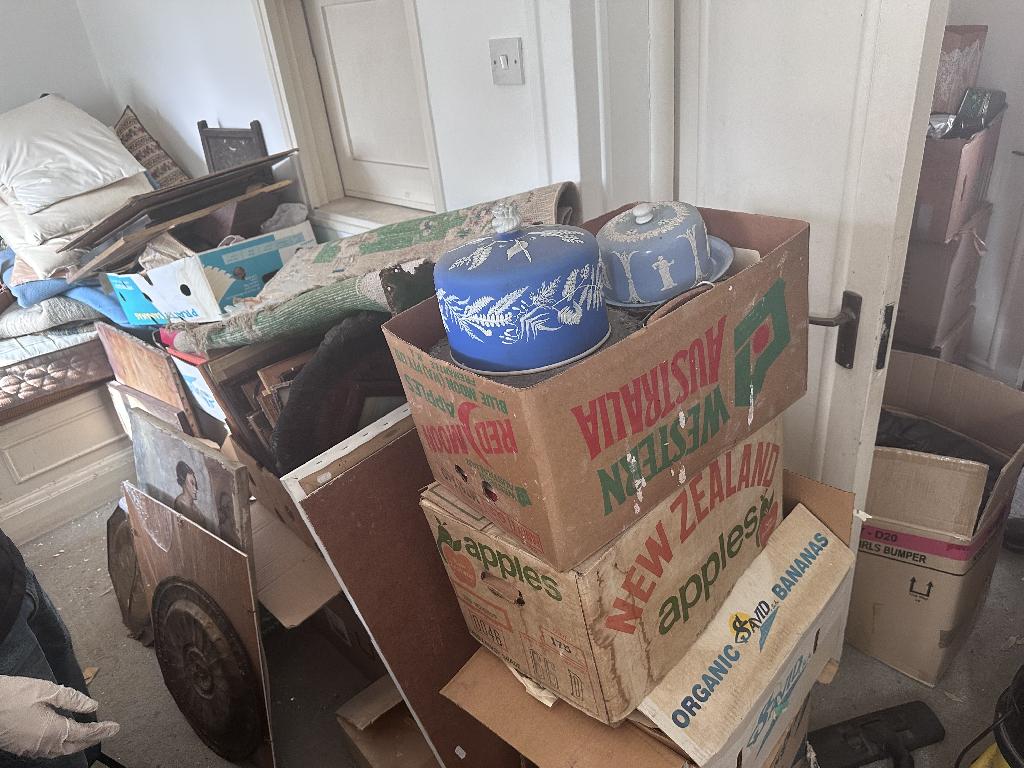 Household clutter clearance in Chelsea before service, showing boxed clutter and items