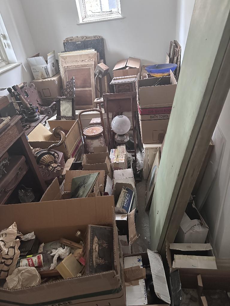 Flat clearance in Chelsea before service, showing a cluttered corridor with boxes and waste