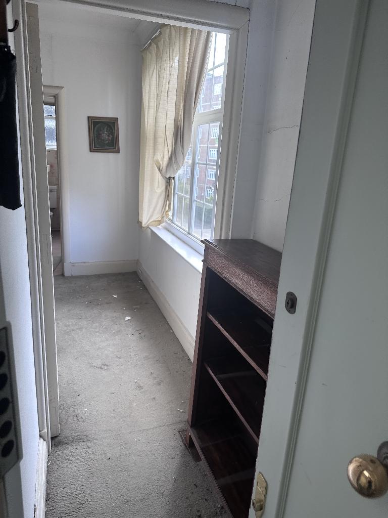 Household clutter clearance in Chelsea after service, showing a cleared doorway floor and cabinet