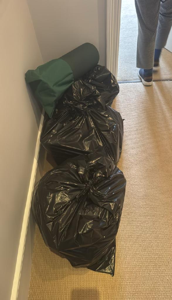 Rubbish removal in Walham Green before the clearance shows bundled black waste bags in a room corner