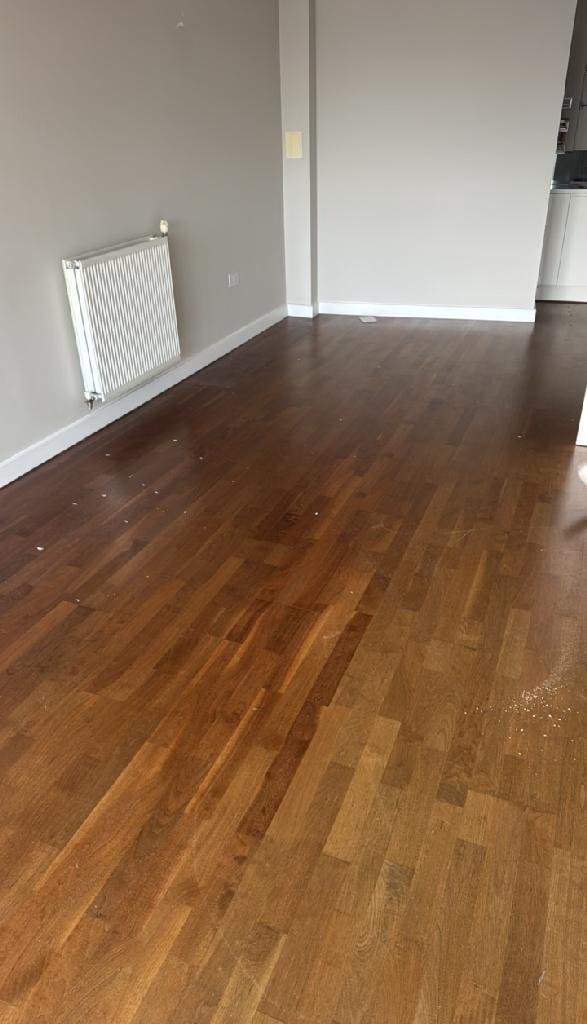 Household furniture clearance in Dalston after clearance, showing open wooden flooring with walls and radiator area ready for use