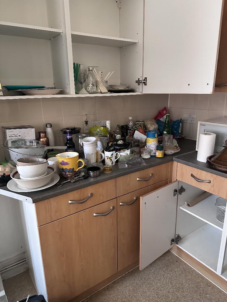 Rubbish removal in Rotherhithe before clearance shows an overloaded kitchen counter and stored items