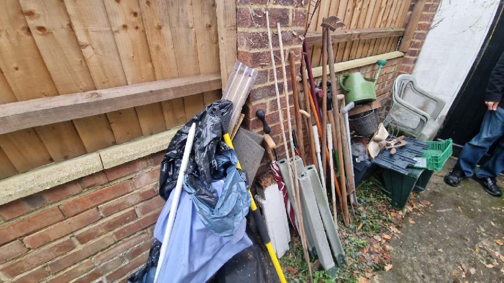 Side passage before clearance in Pinner South, side garden area with mattress and mixed waste pile