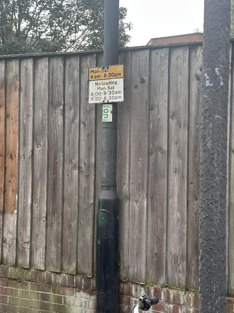 Property frontage in Walham Green before clearance, showing items left against boundary fencing