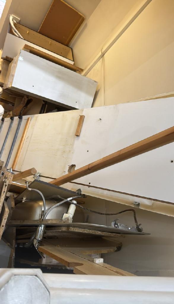 Flat clearance in North Acton - before the clearance shows cabinet carcasses and wood pieces along the wall