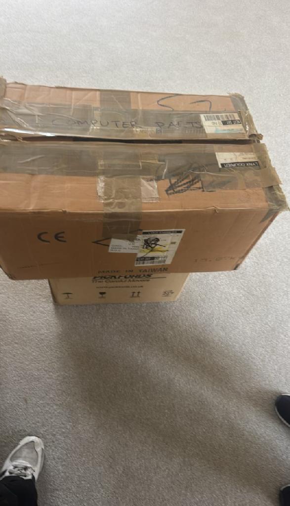 Rubbish removal in Walham Green before the clearance shows stacked cardboard parcels on the floor in a cluttered indoor corner