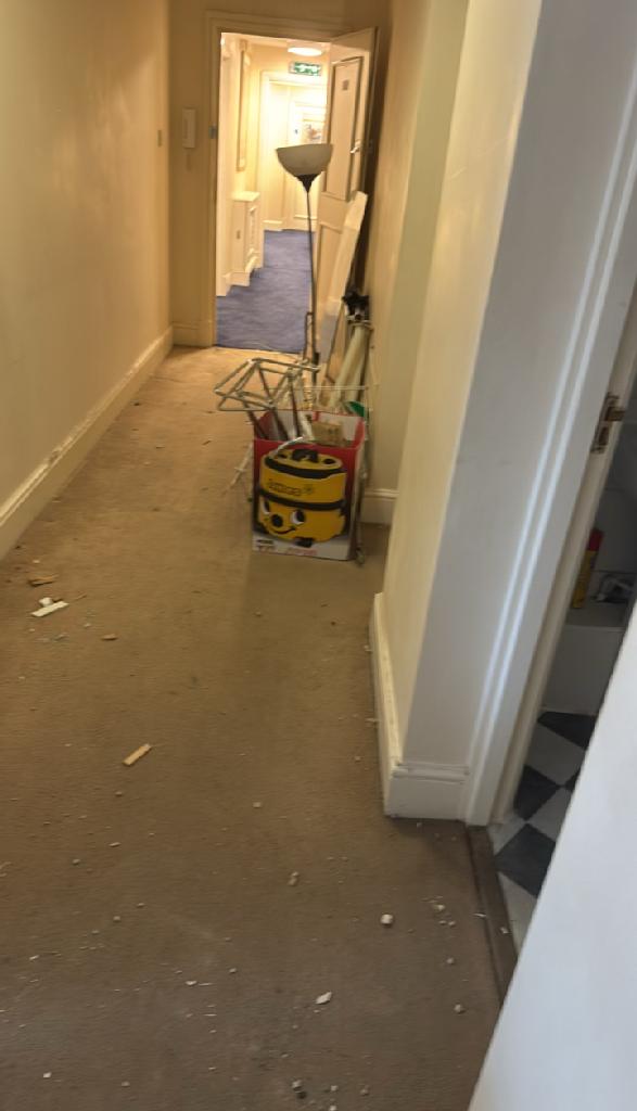 Home renovation waste clearance in Marylebone before clearance shows waste bags and debris along a hallway corridor