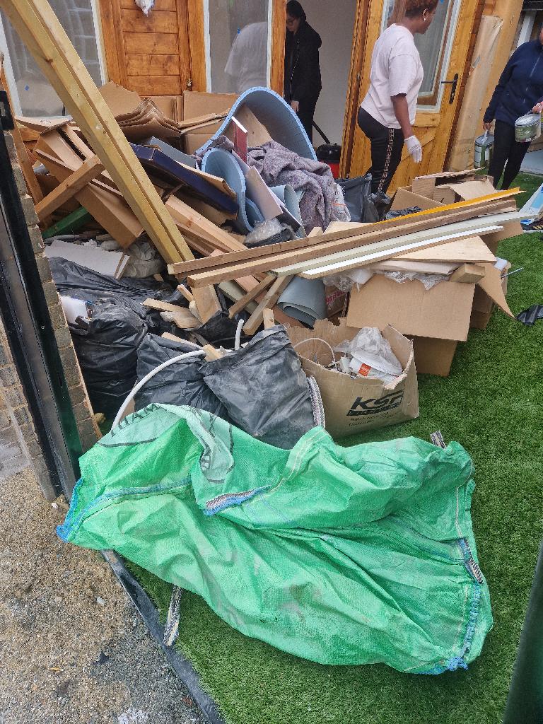Rubbish removal before in Thames View: construction waste and building debris scattered on the lawn