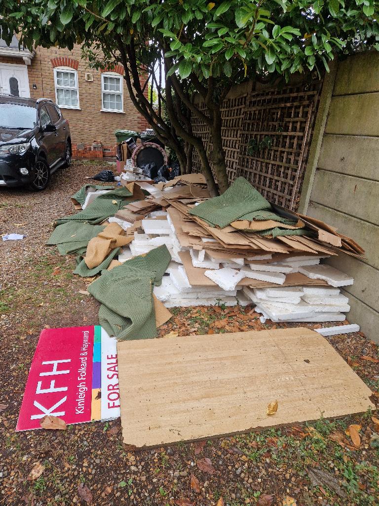 Yard clearance in Catford before removal showing cardboard and packing materials piled in the yard
