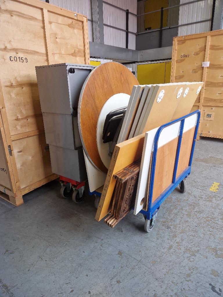 Household storage clearance in Peckham before service, showing bulky stacked wooden panels and mixed waste in a storage area