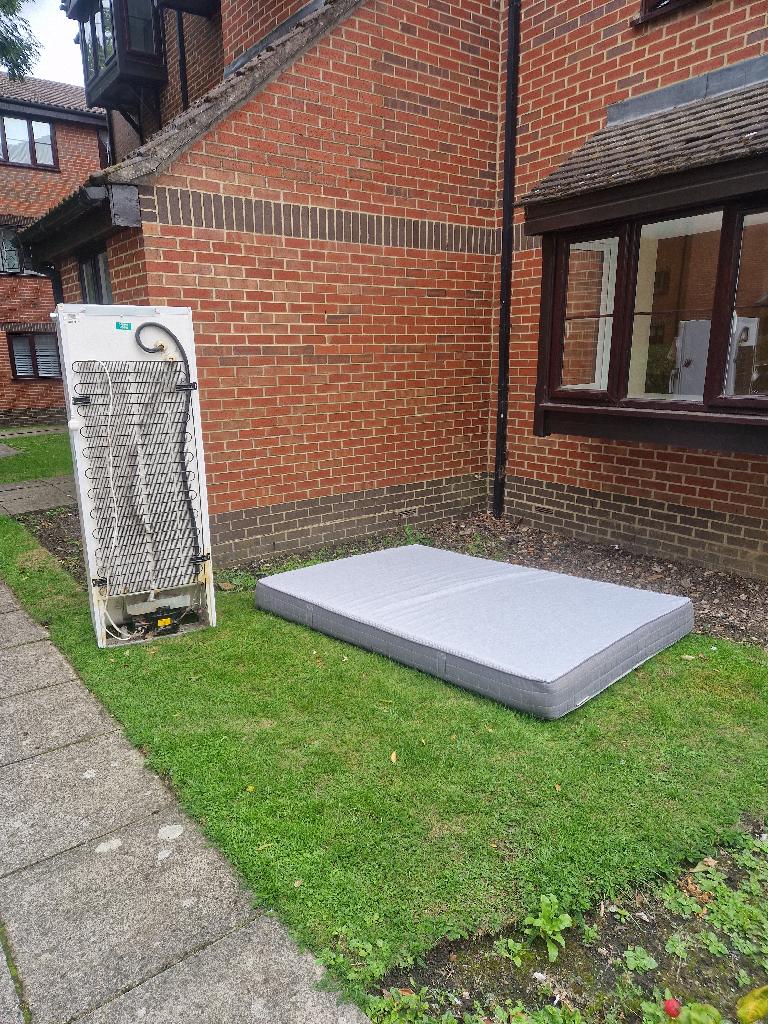 Mattress and appliance clearance in Enfield - before: mattress on the lawn and a fridge positioned near the garden frontage