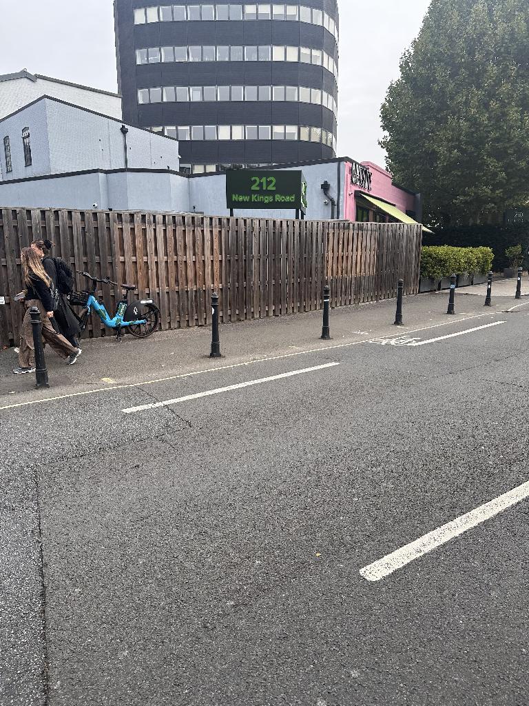 Property frontage in Walham Green before clearance, showing cluttered boundary area outside the building