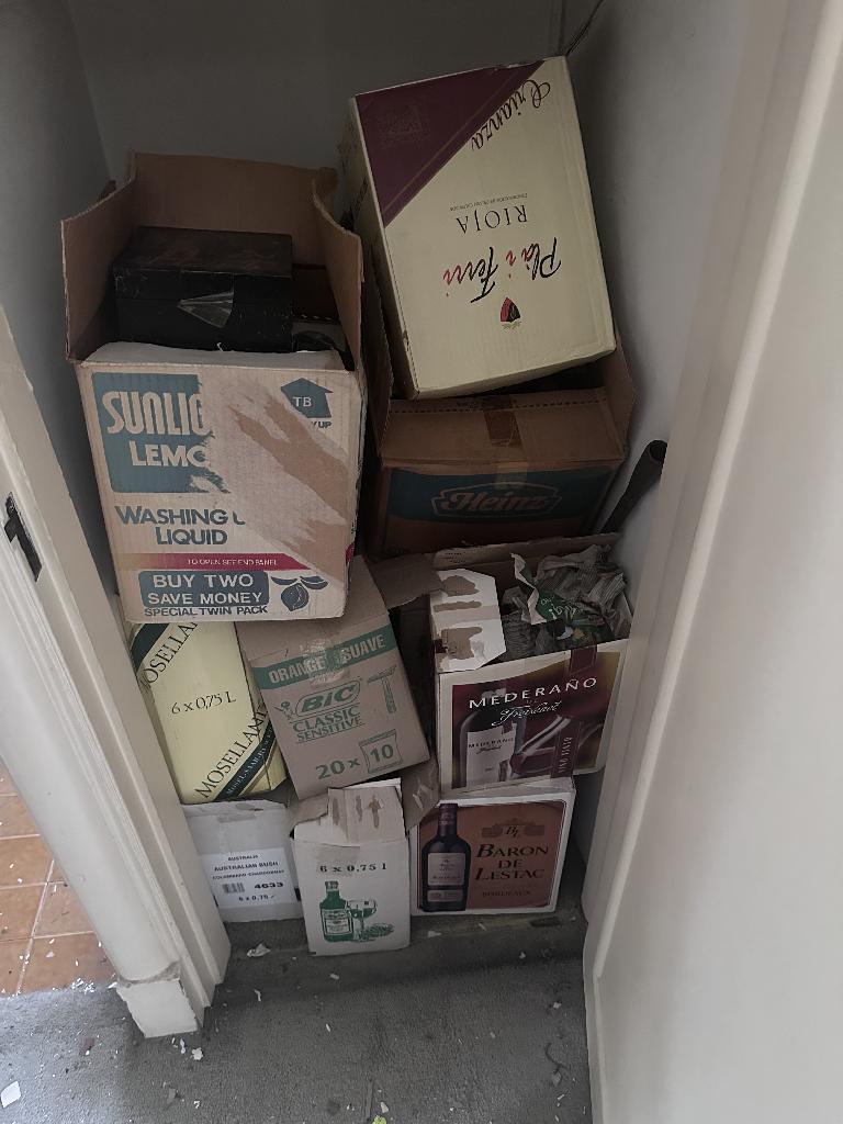 Flat clearance in Chelsea before service, showing stacked household packaging boxes