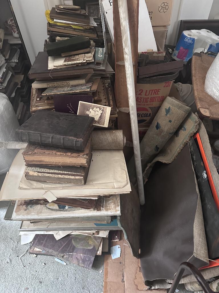 Flat clearance in Chelsea before service, showing stacked boards and waste piles
