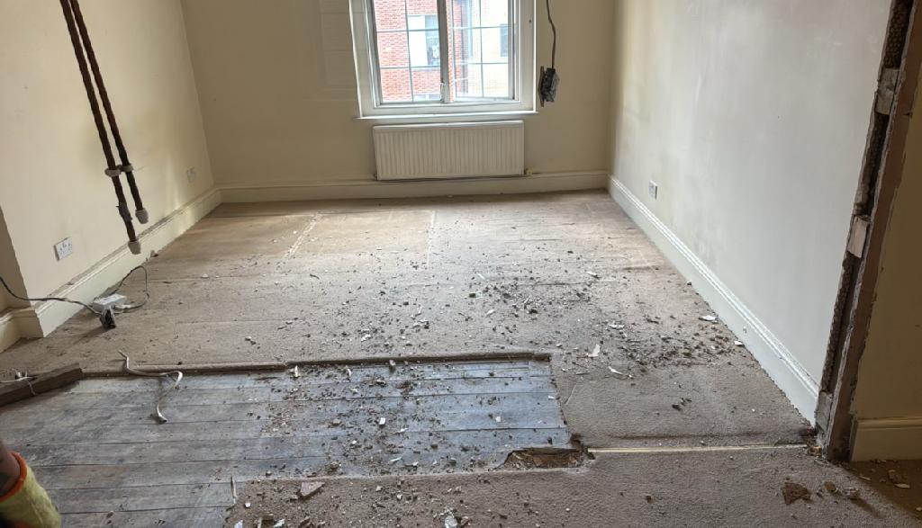 Home renovation waste clearance in Marylebone after clearance shows an open room floor with debris largely removed near the window