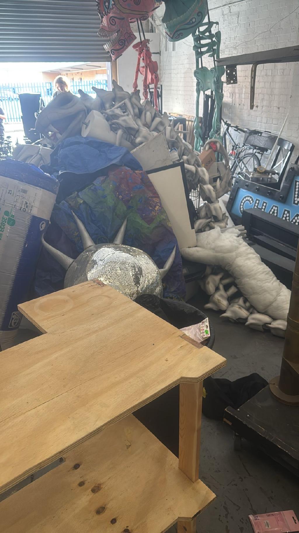 Rubbish removal before in Dollis Hill showing stacked waste bags and soft items blocking usable floor space