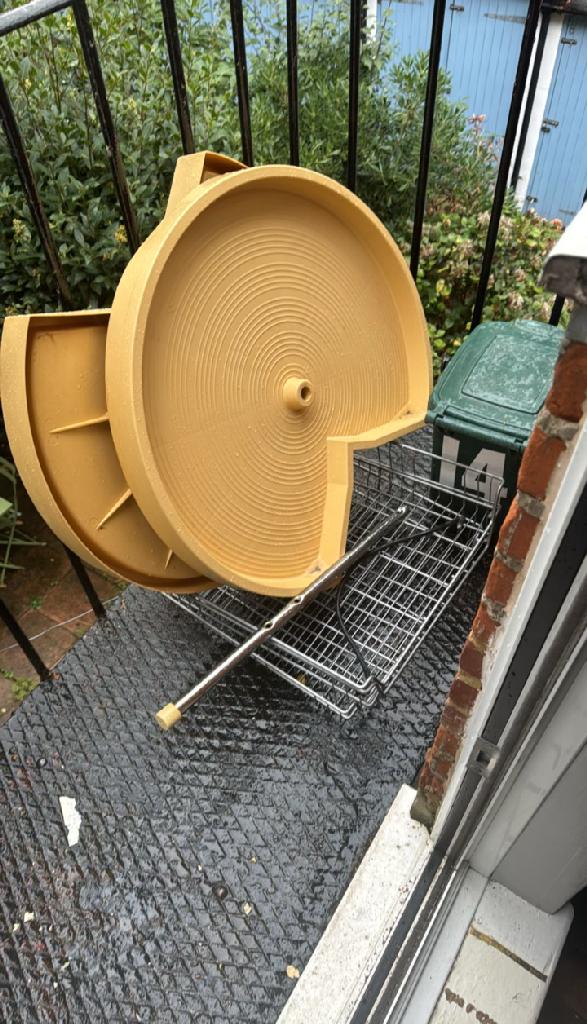 Flat clearance in North Acton - before the clearance shows bulky carpet rolls staged outdoors near a fence