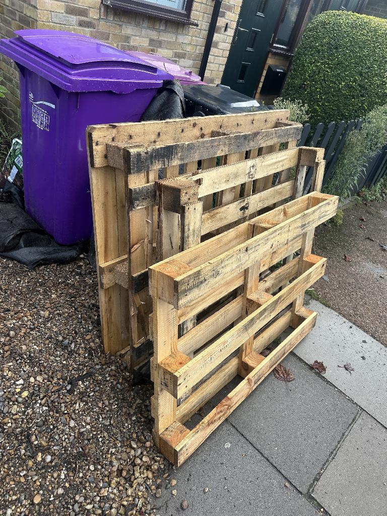 Home renovation waste clearance in Whitechapel before clearance showing three wooden pallets and plasterboard waste stacked by the path